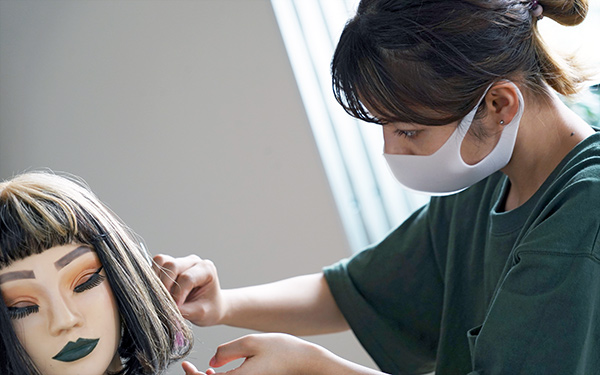 ヘアセットの微調整をおこなう学生